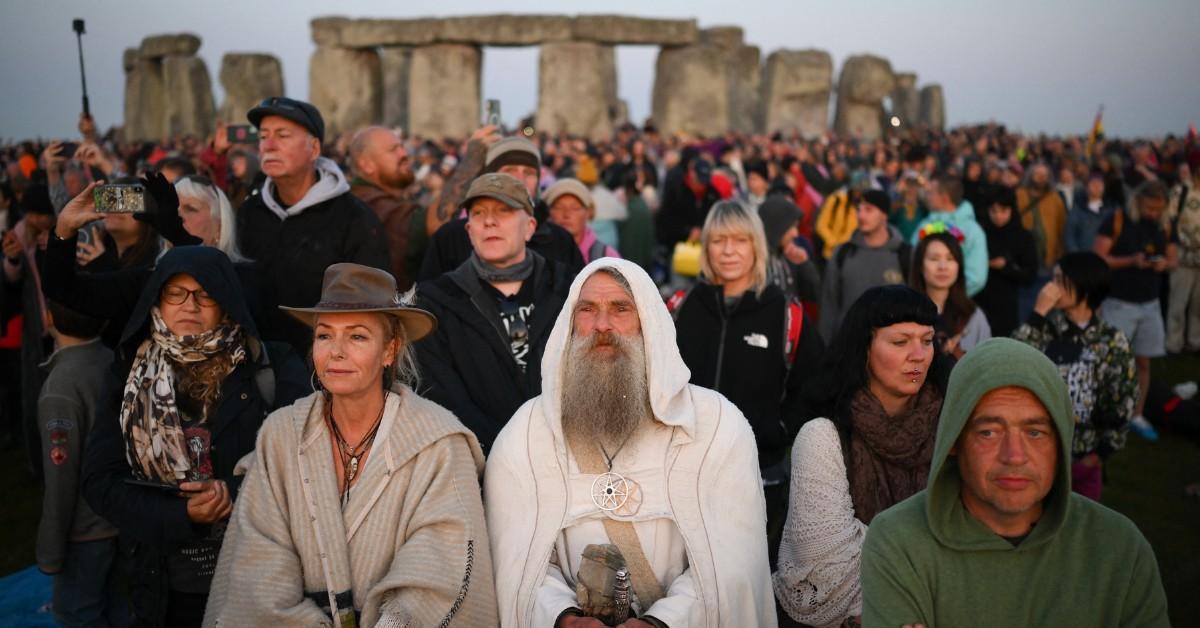 People gather at Stonehenge to watch the sunrise during the Summer Solstice